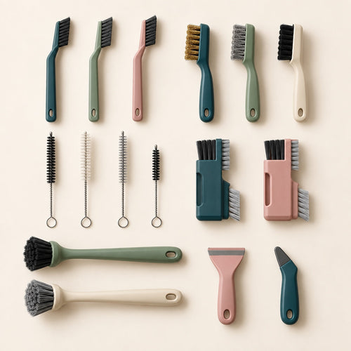 Sixteen detail cleaning brushes and scrapers arranged on a warm ivory background