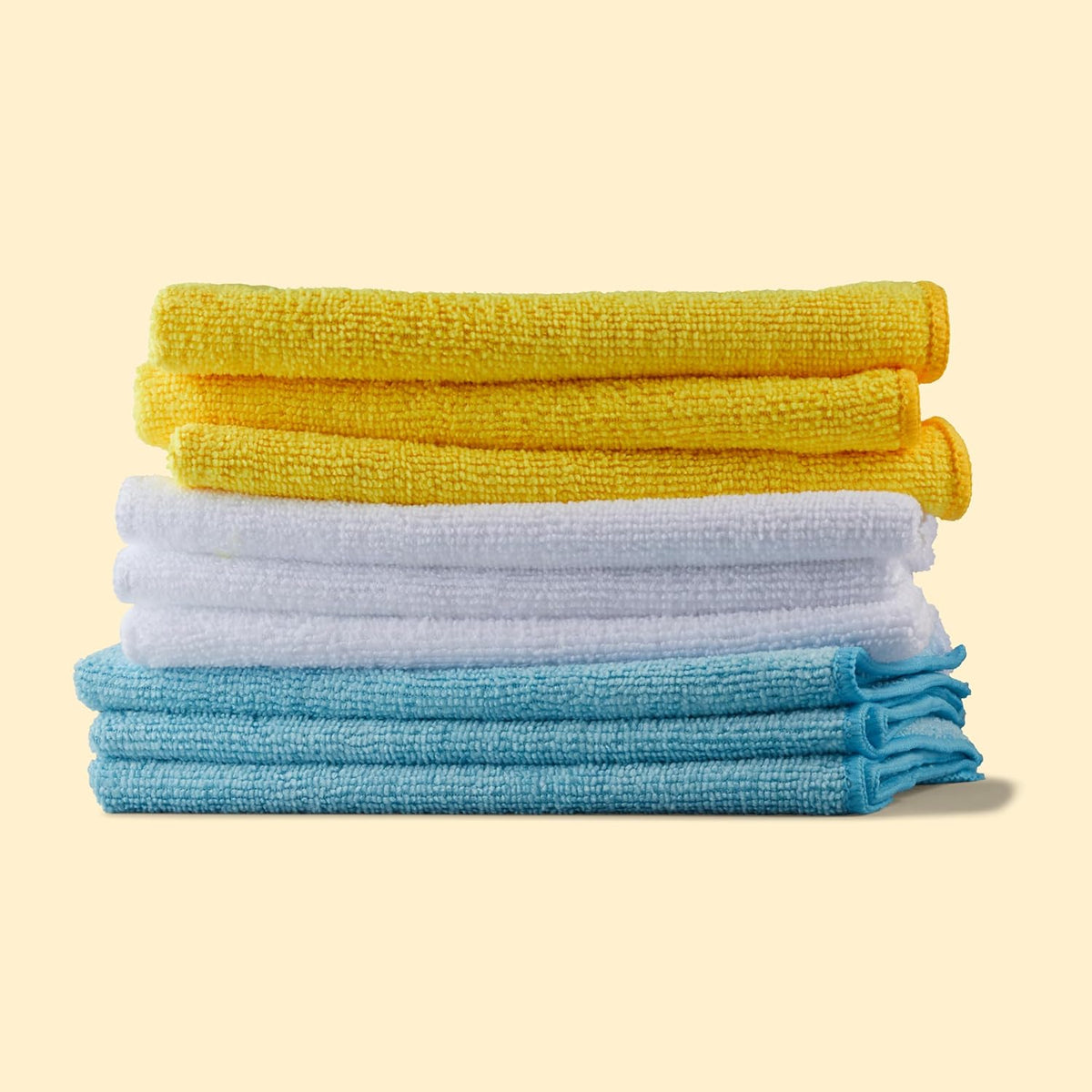 Folded yellow white and blue microfiber cleaning cloths stacked together